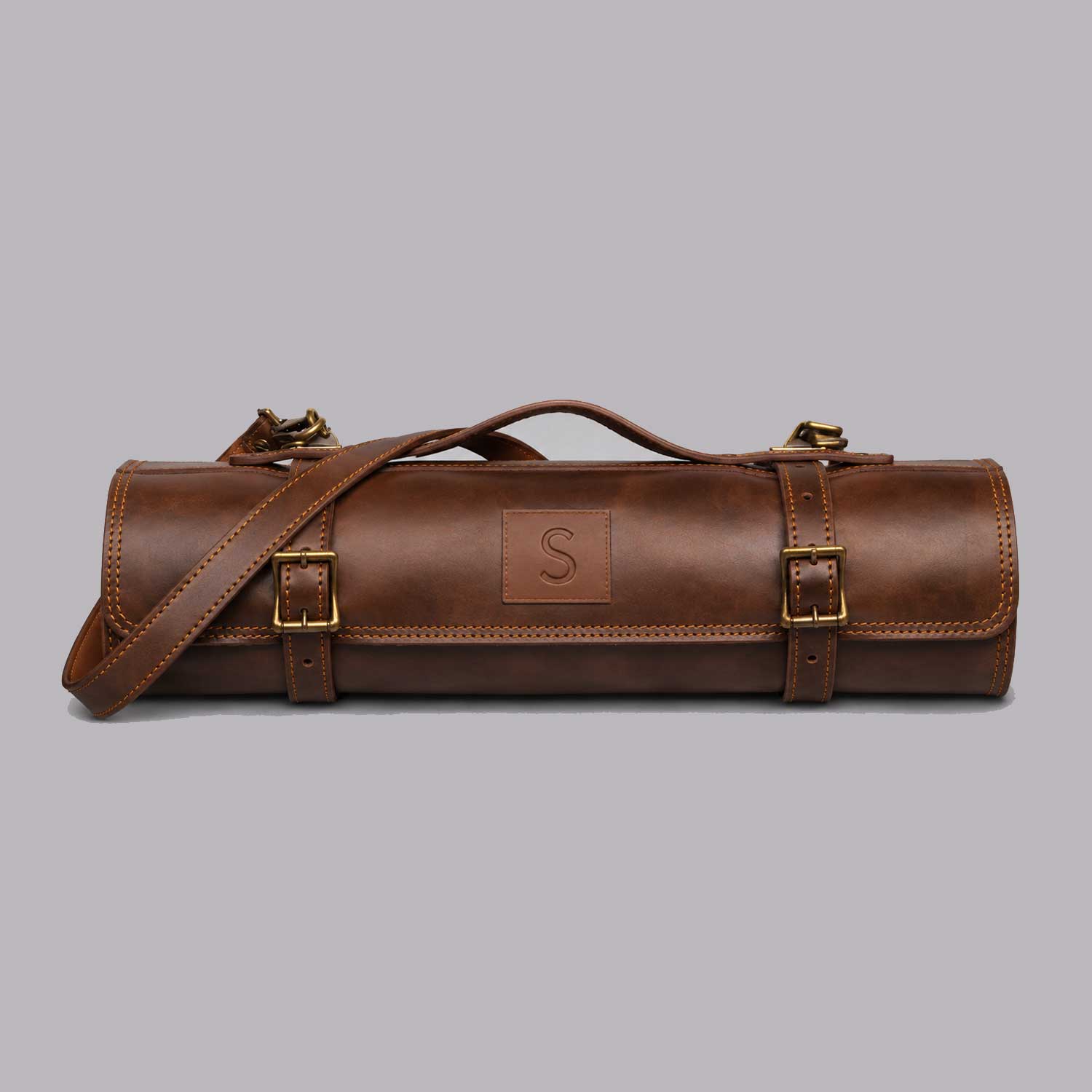 Brown full grain cow leather chef knife roll holding 6 knives with shoulder strap and zipper pocket